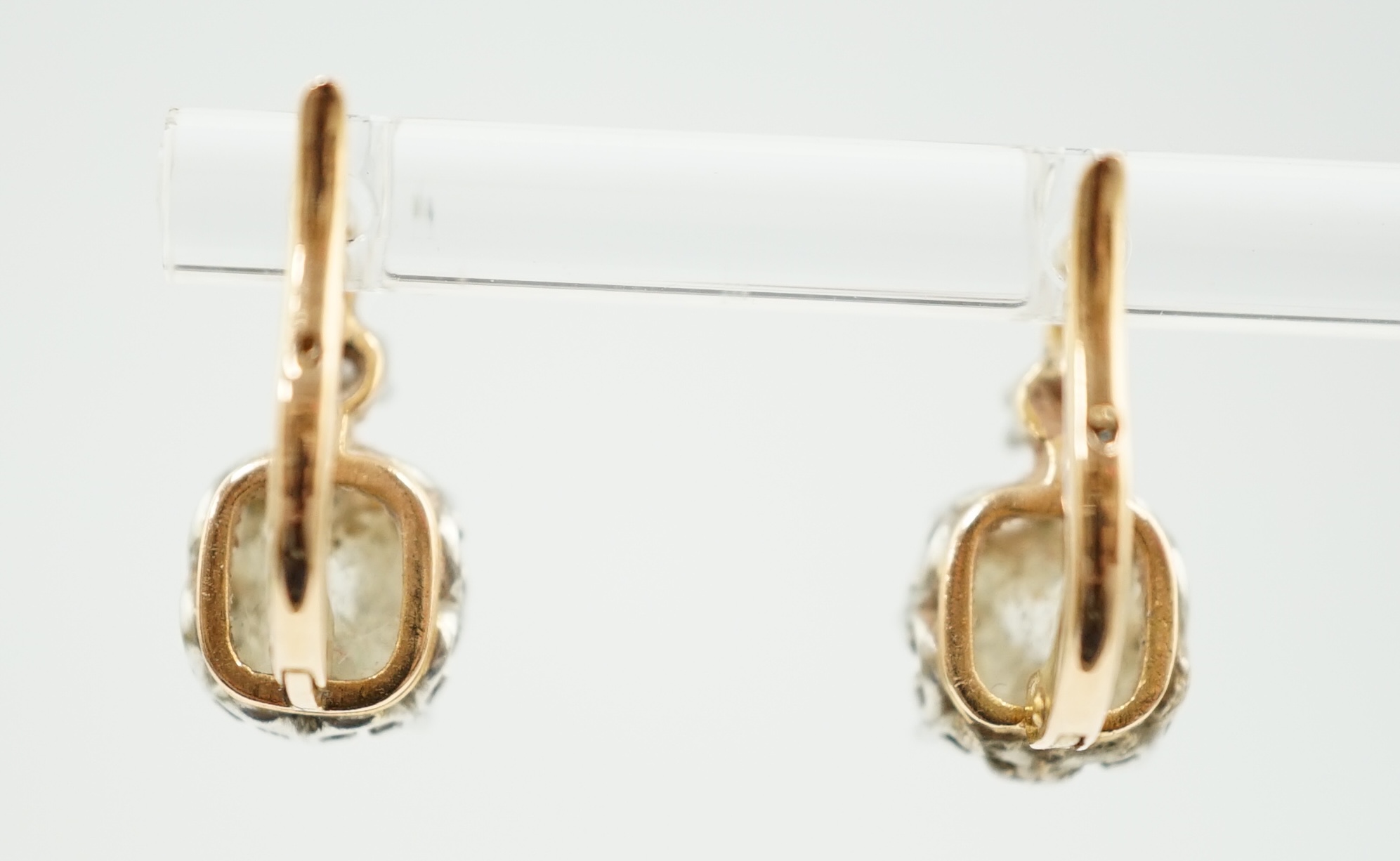 A pair of late 19th/early 20th century gold and two stone cushion cut diamond set earrings